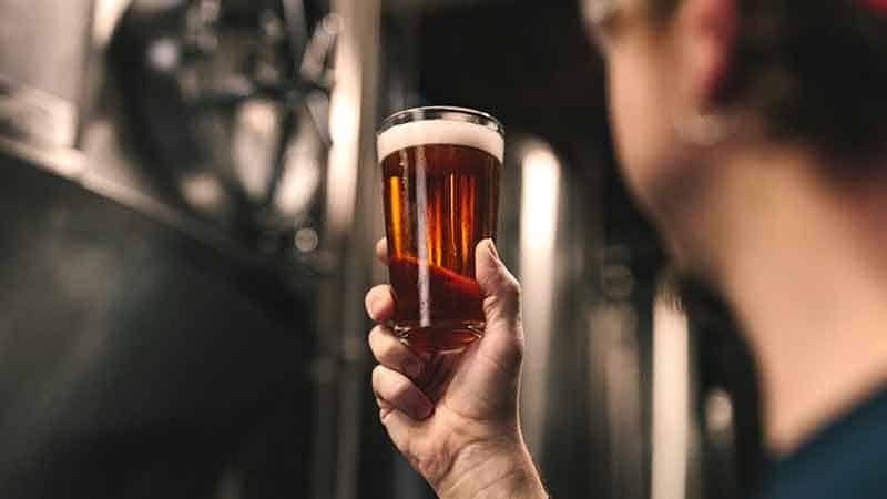 home brewing affiliate programs - man holding beer